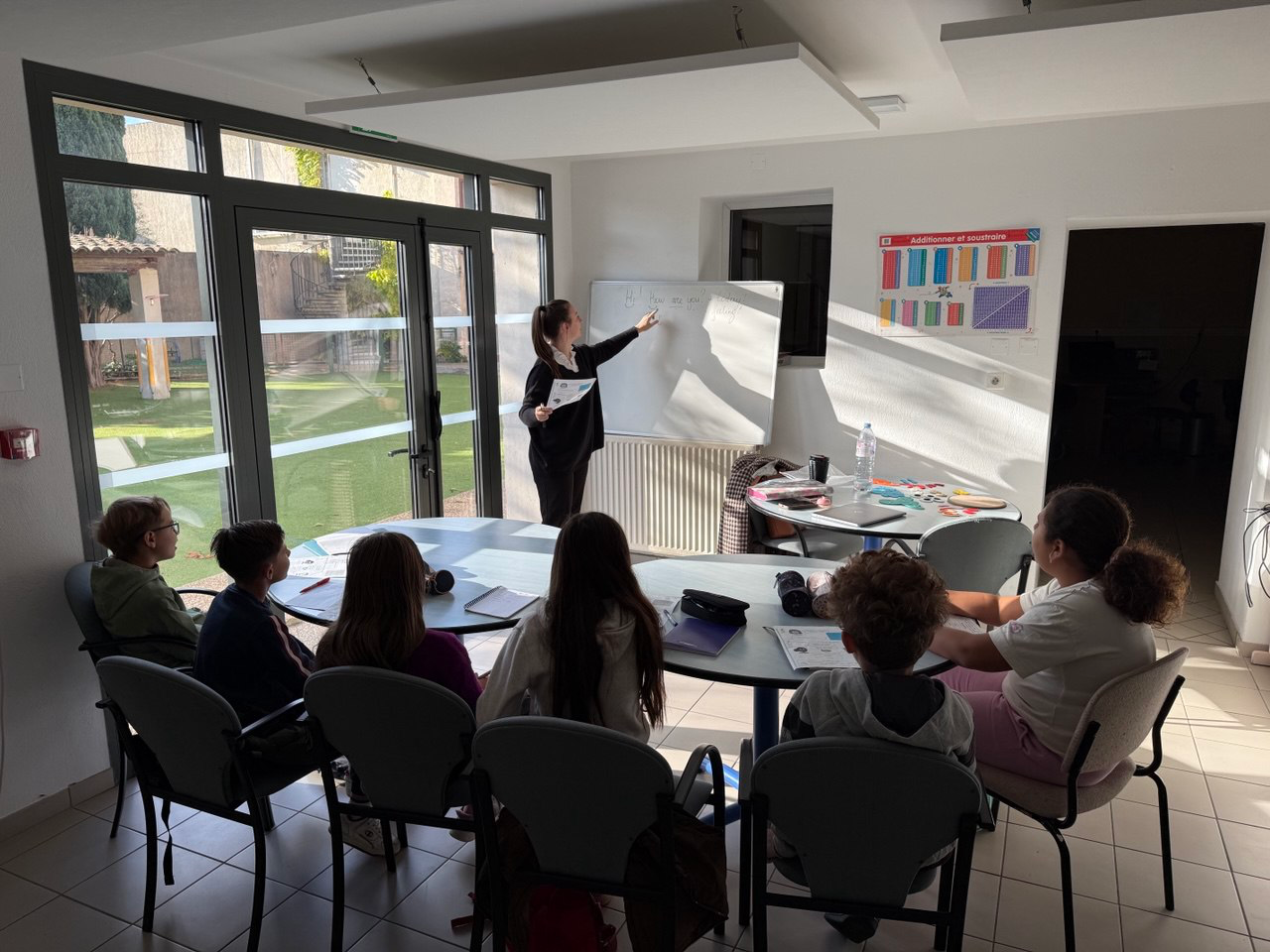 Cours d'anglais avec plusieurs élèves et tableau blanc